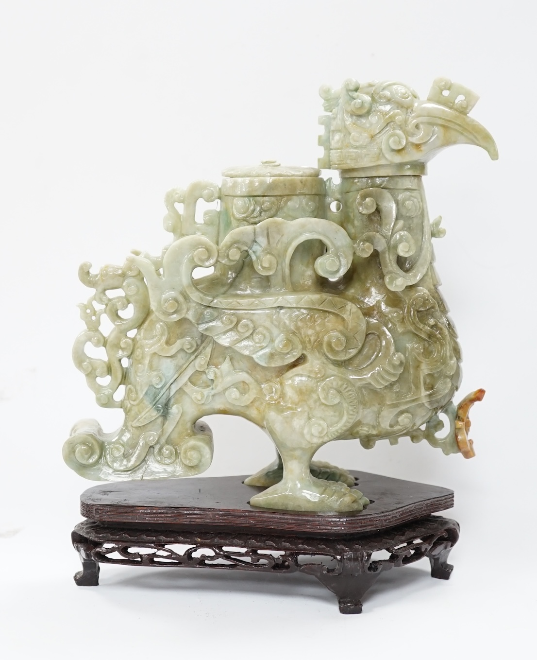 A large Chinese archaistic jadeite ‘phoenix’ vessel and cover, wood stand, 22cm high. Condition - fair